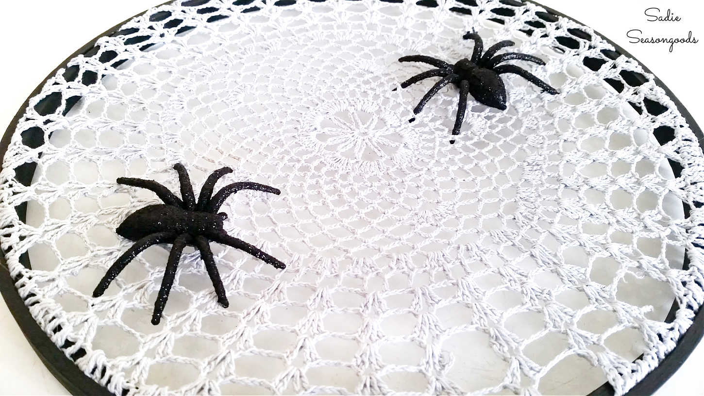 fake spiders on a spider web doily