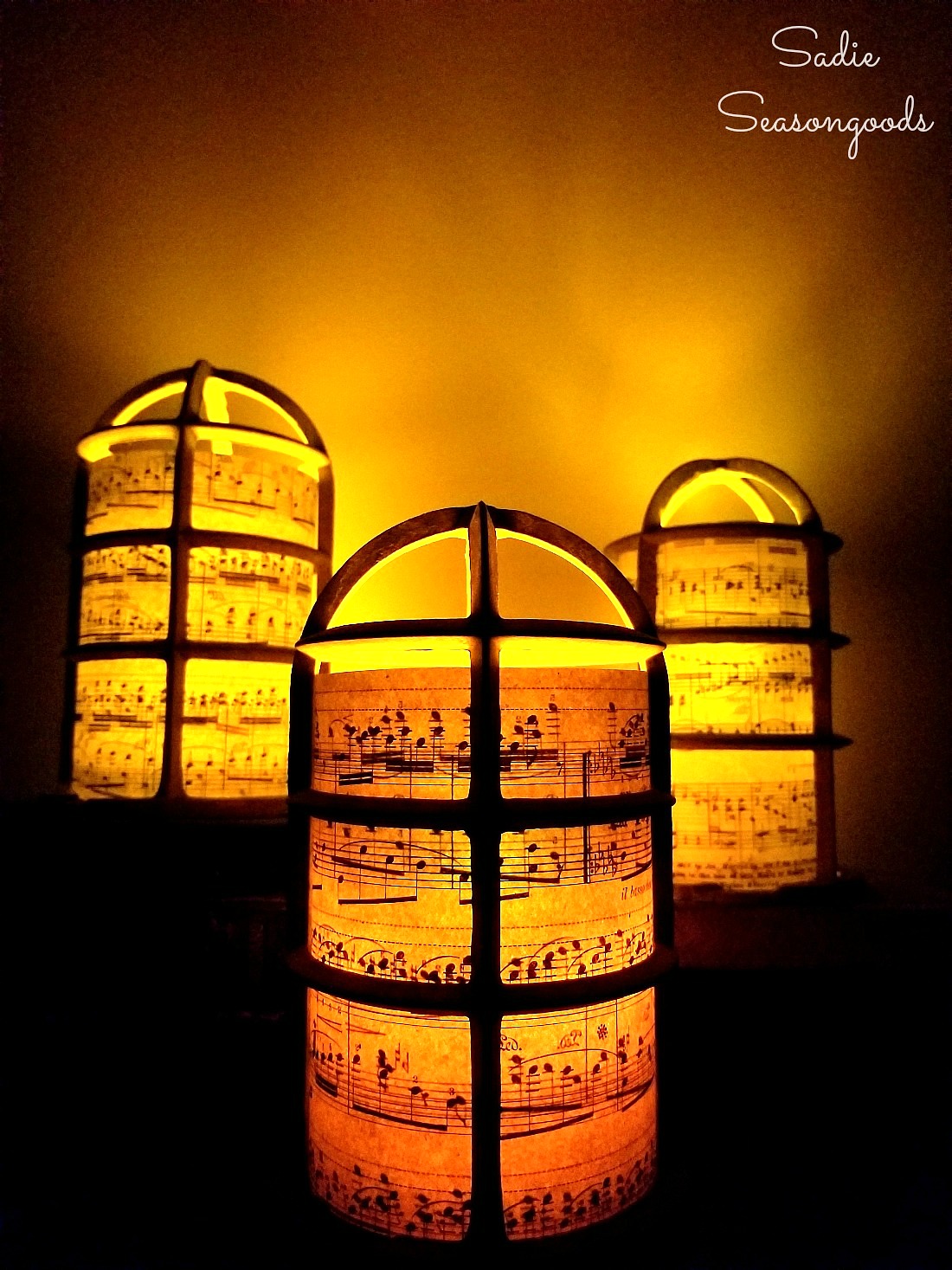 Christmas lantern or Christmas luminaries with a light bulb cage and old sheet music