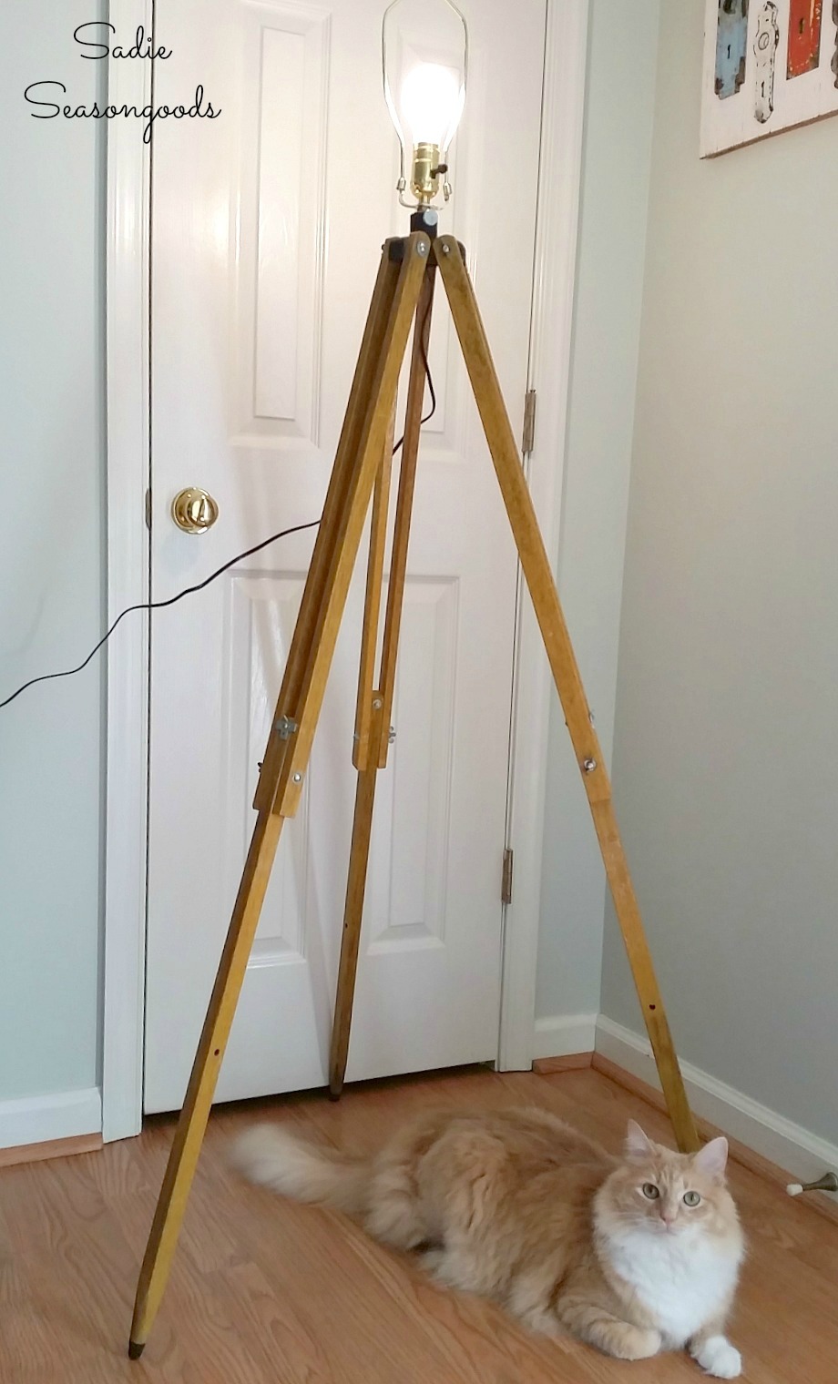 Industrial floor lamp made by wiring a lamp kit inside a surveyors tripod or wooden tripod by Sadie Seasongoods / www.sadieseasongoods.com