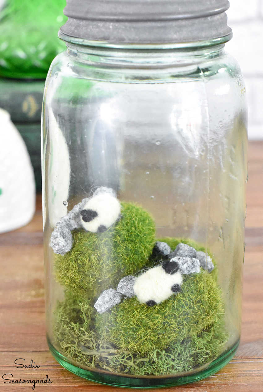 tiny felted sheep on moss rocks