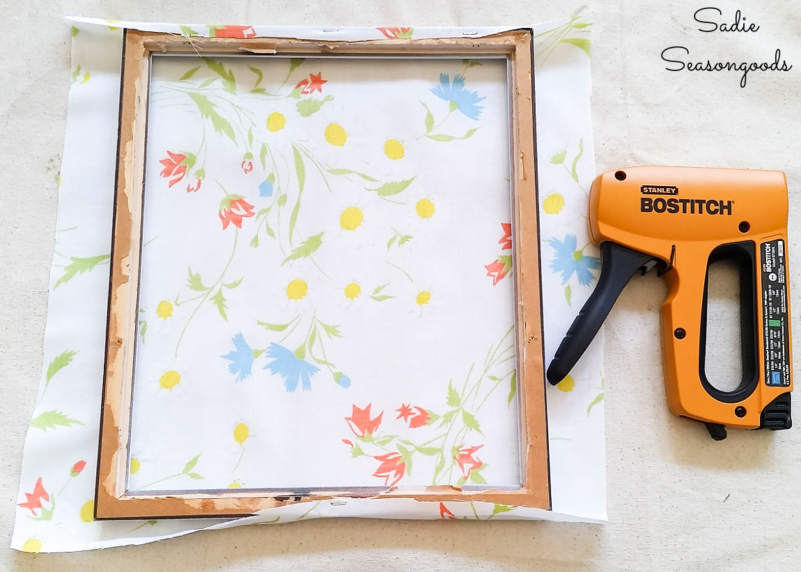 attaching the vintage floral sheet to a wood frame