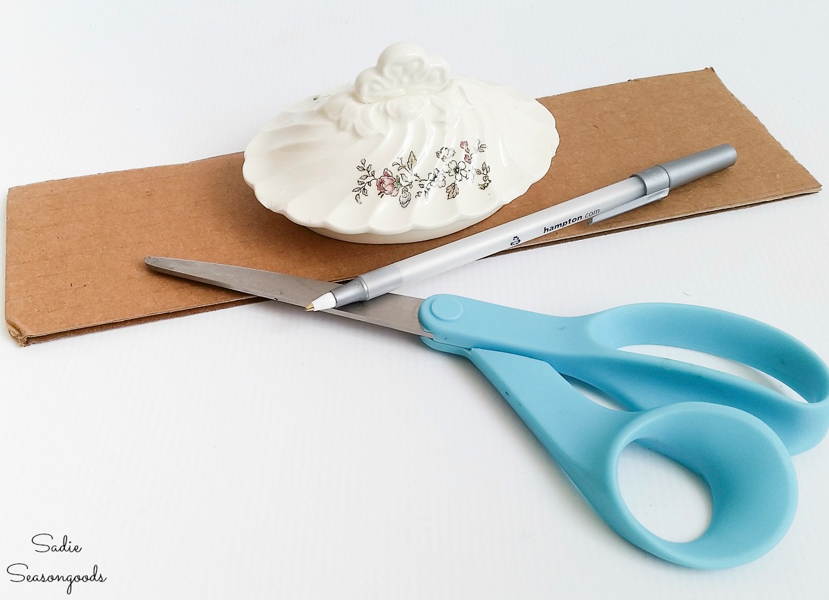 Craft supplies for making a DIY pin cushion in the lid of a small teapot from the thrift store