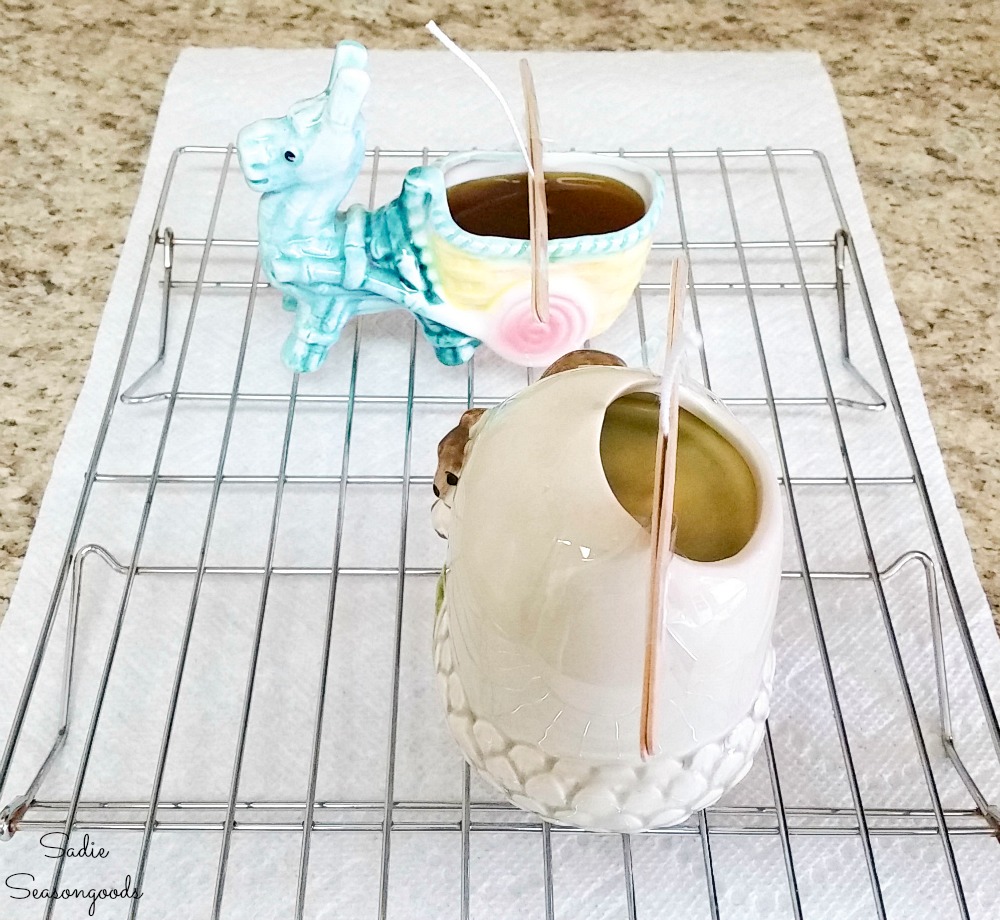 Mosquito candles on a cooling rack after getting poured in vintage planters