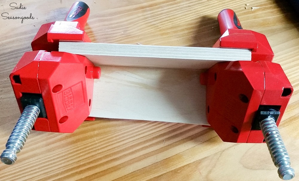 Clamps holding wood pieces together at a 90 degree angle