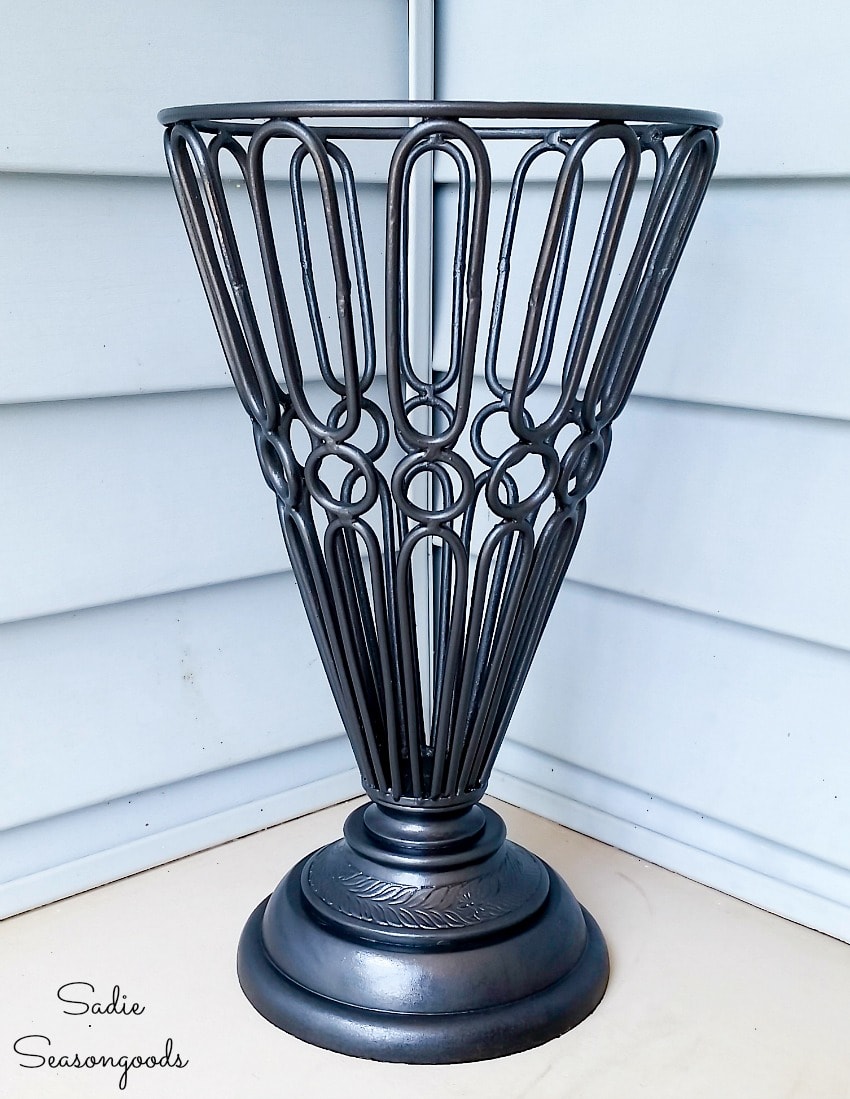 Garden urn that has been upcycled to be a cast iron umbrella stand