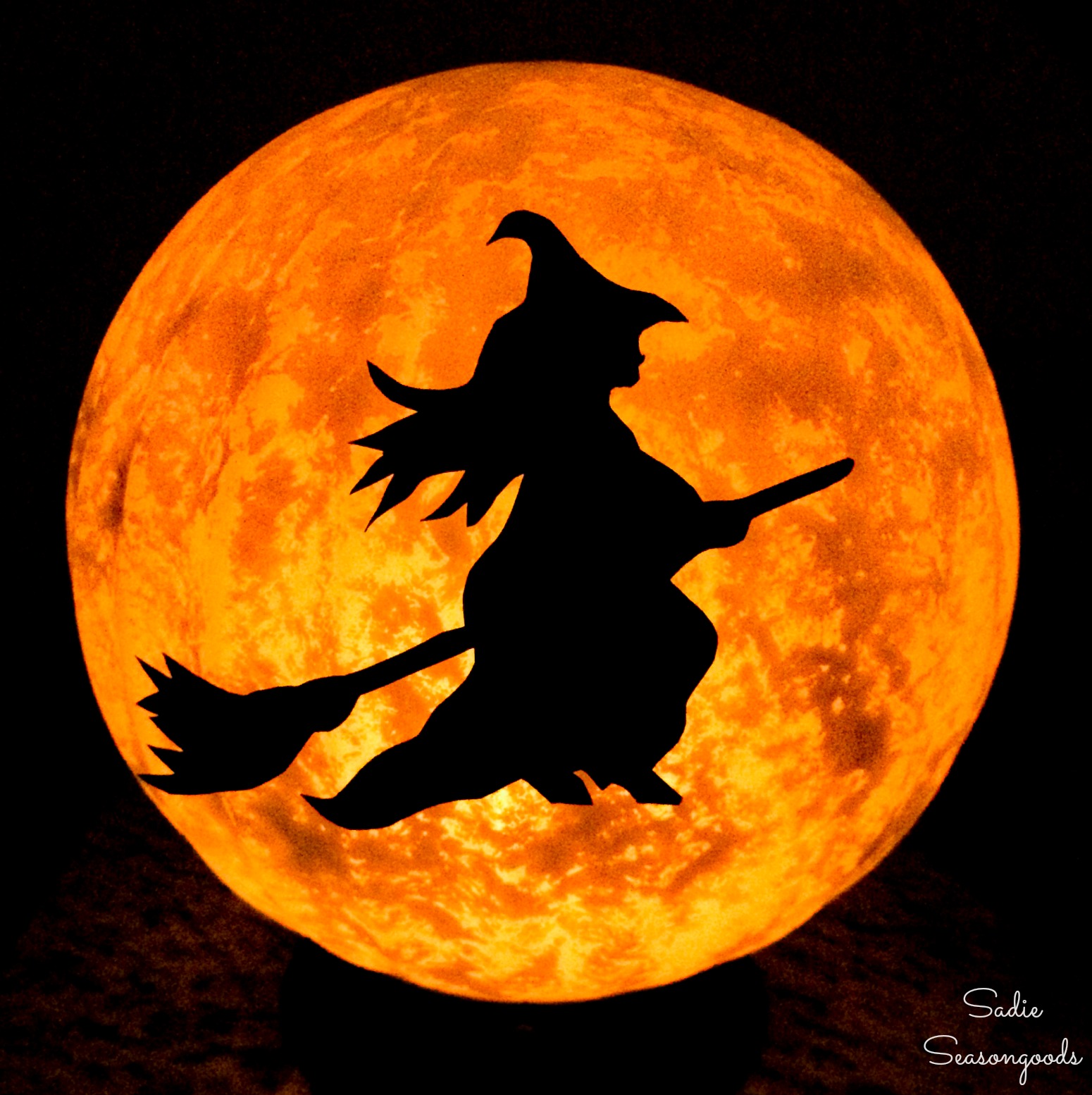 Halloween moon and witch decor from a glass globe light fixture