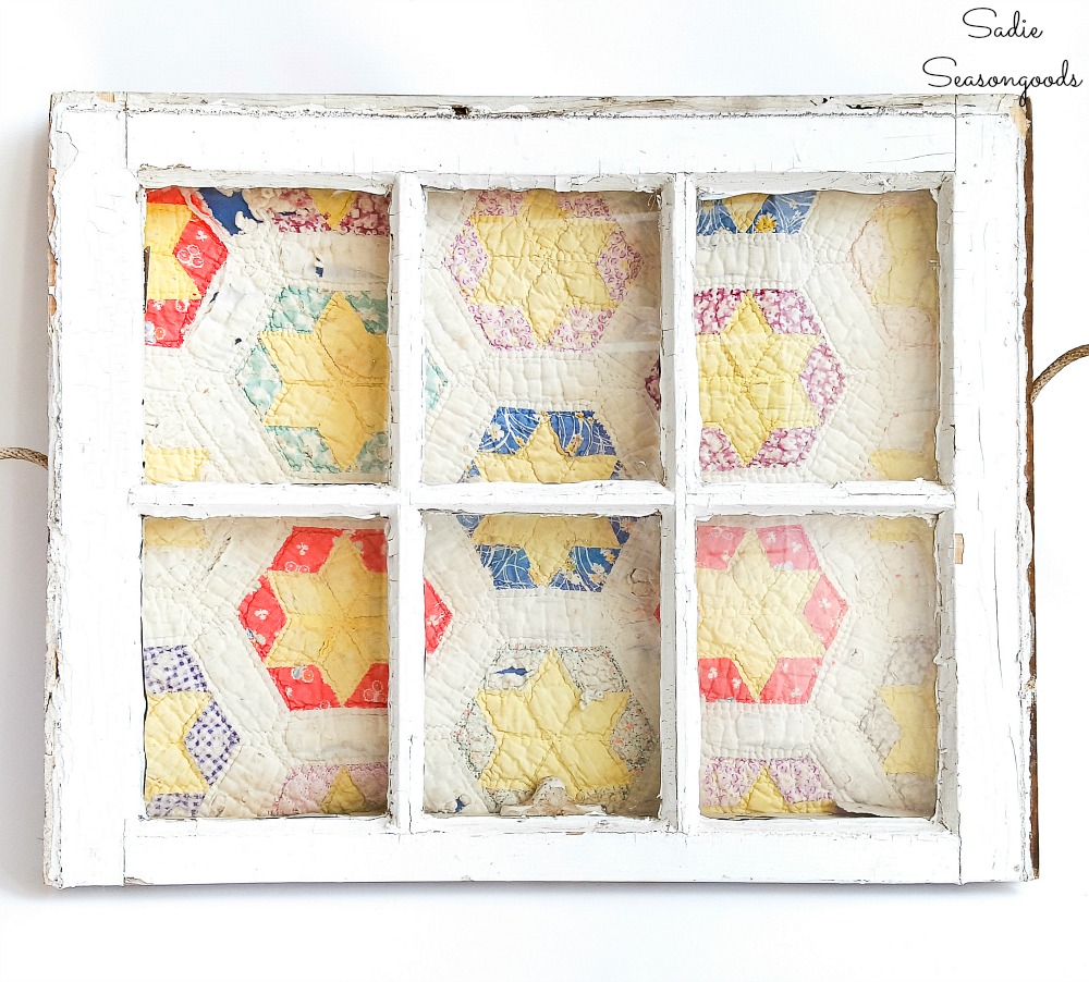 Quilt display in a vintage window for primitive decor