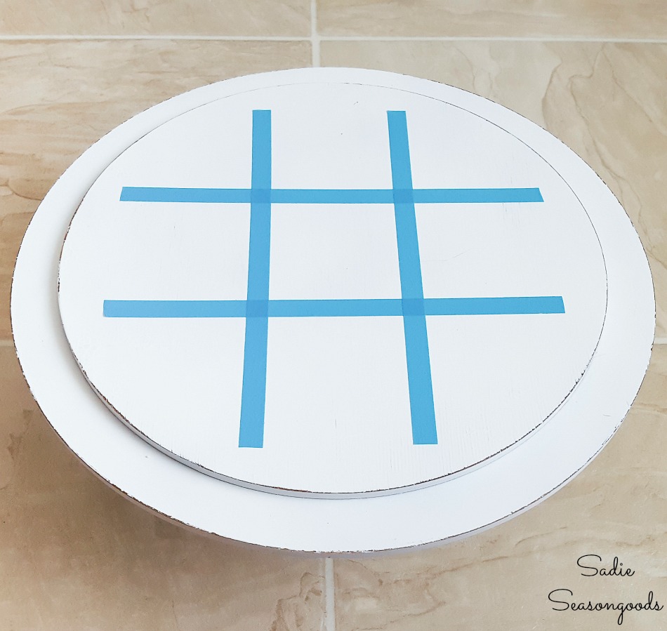 Tic tac toe game board with a wooden cake stand