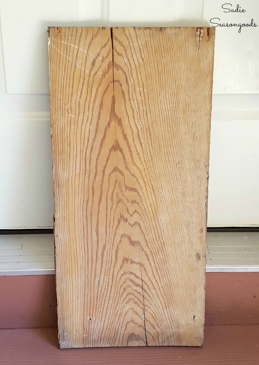 Sanding down salvaged wood or reclaimed wood before applying wood stain for barn decor by Sadie Seasongoods