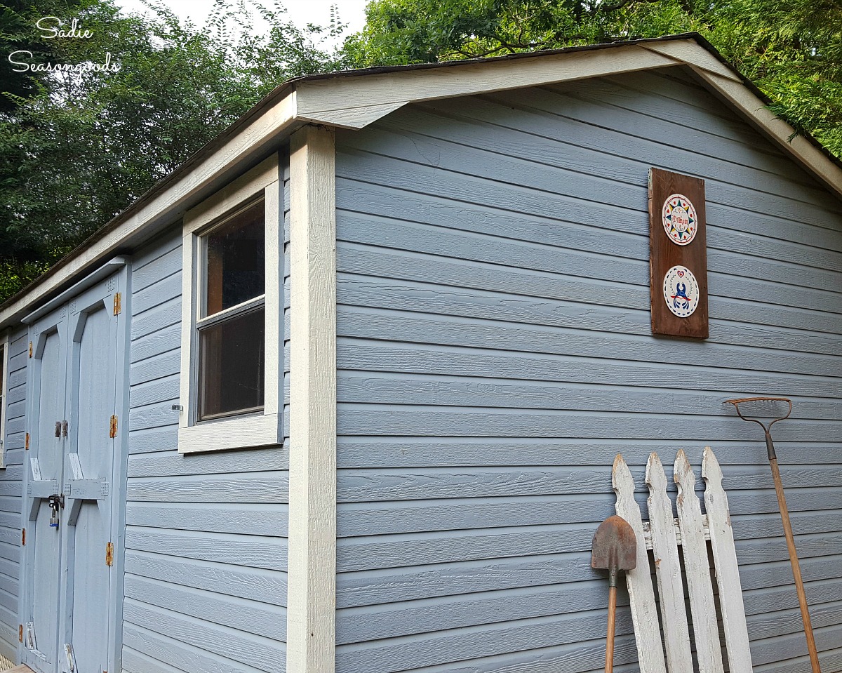 Outdoor wall decor on a tool shed with hex signs on salvaged wood by Sadie Seasongoods