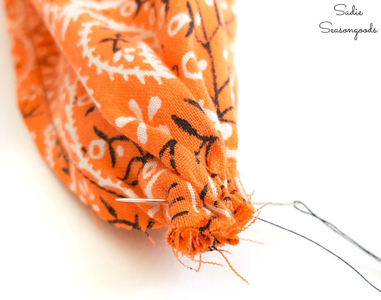 Closing up the bottom of the fabric pumpkin