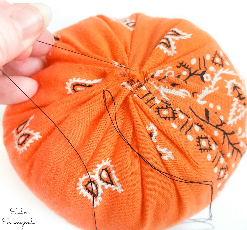 Sewing shut a fabric pumpkin from a Halloween bandana