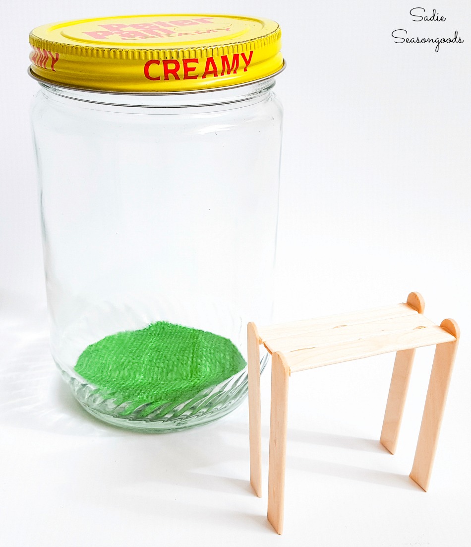 Popsicle sticks to build a potting bench to go in a peanut butter jar for Spring decor ideas