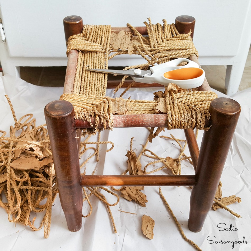 Removing the rush seat on a low footstool for furniture restoration