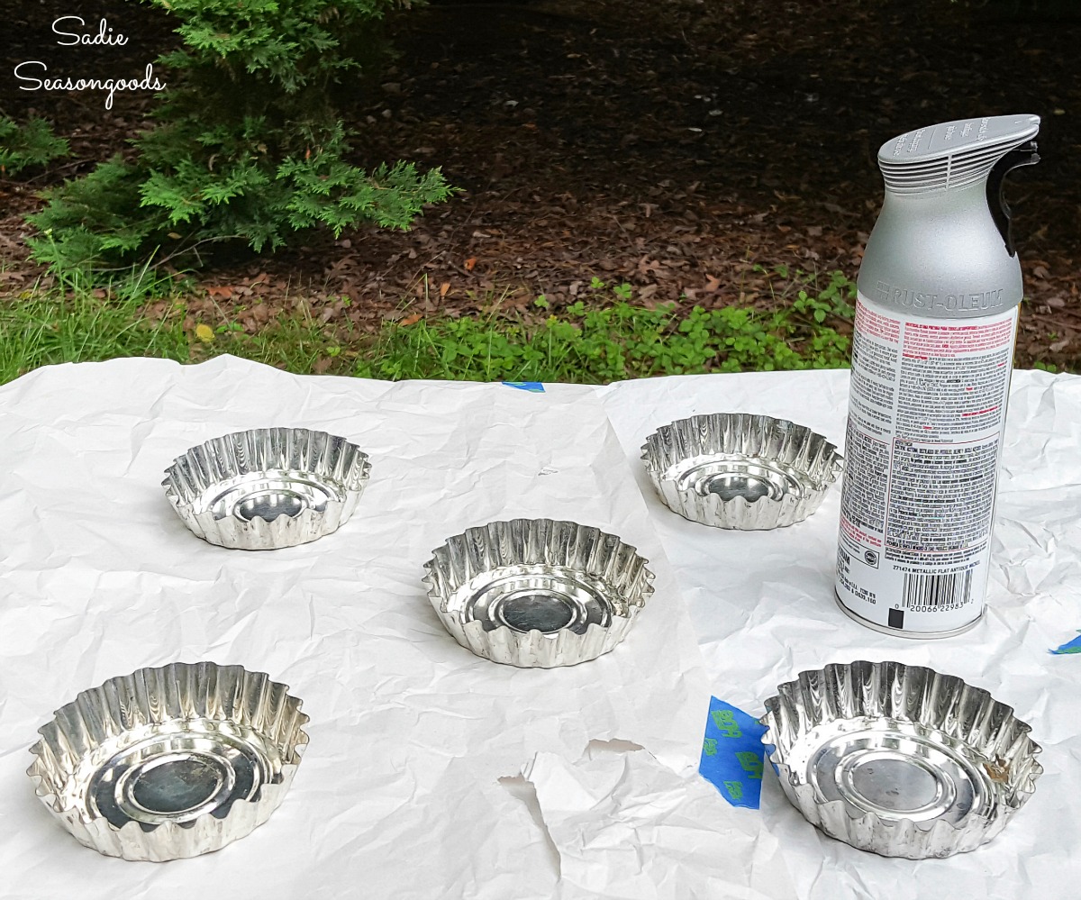 Spray painting the mini tart pans to look like bottle caps