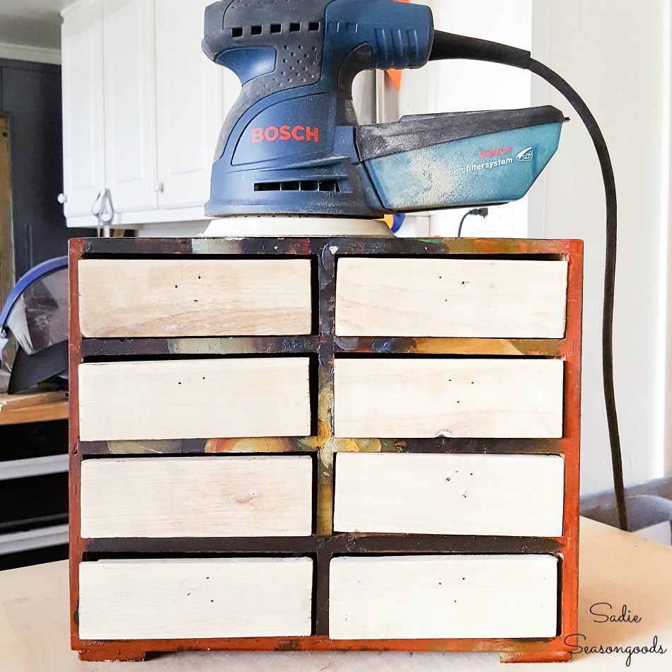 Refinishing a mini chest of drawers by sanding off the paint