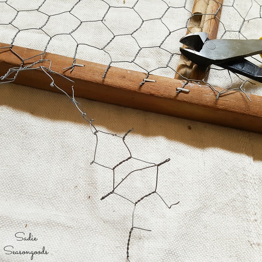 Trimming the chicken wire that was attached to the back of a vintage washboard