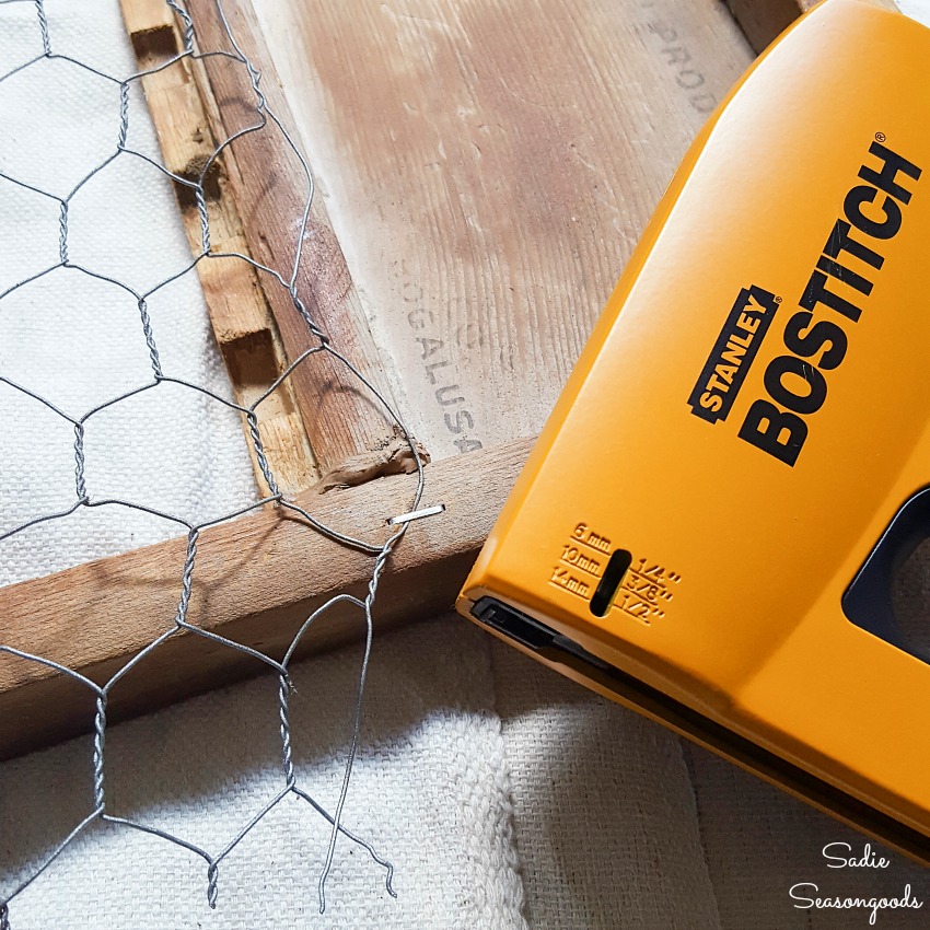 Using a staple gun to make a chicken wire frame with an antique washboard