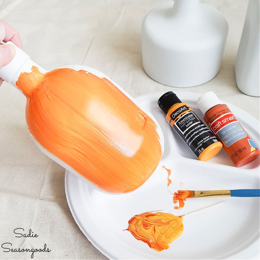 painting glass bottles as pumpkin decor