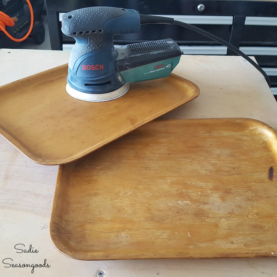 Using an orbital sander on wood tray before staining it and upcycling it into rustic home decor or Buffalo check decor