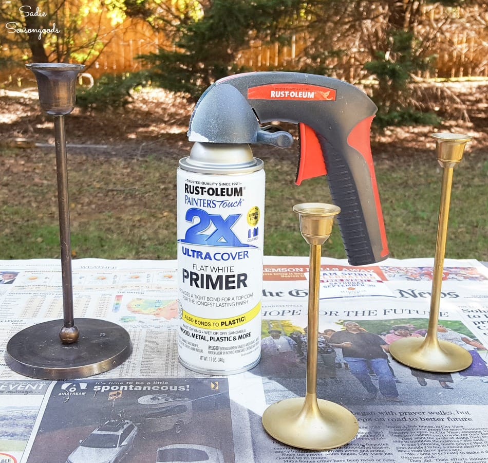 Spray painting the metal candlesticks with white primer