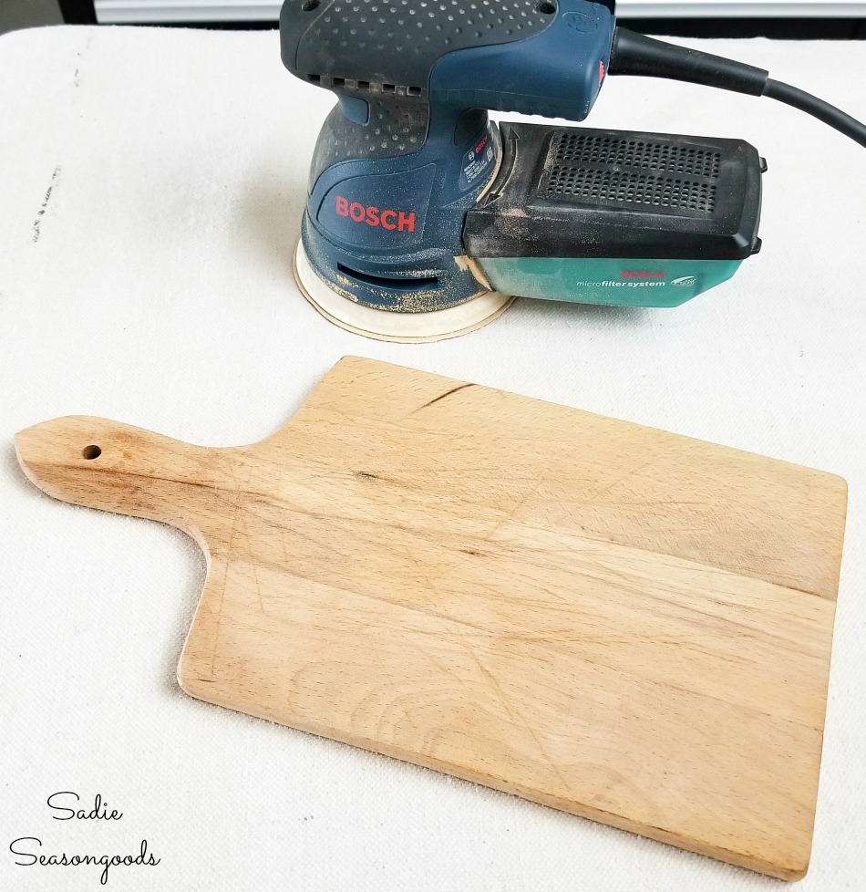 Sanding a cutting board to use as French farmhouse decor