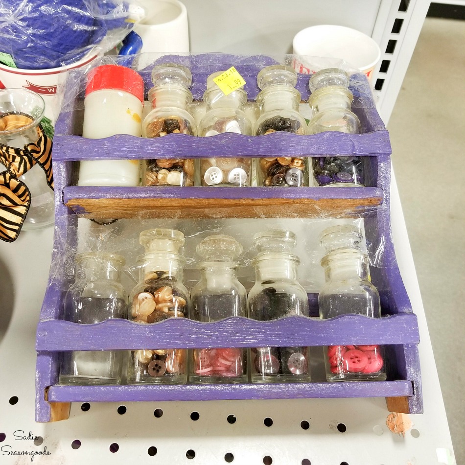 Vintage spice rack with glass jars at a thrift store