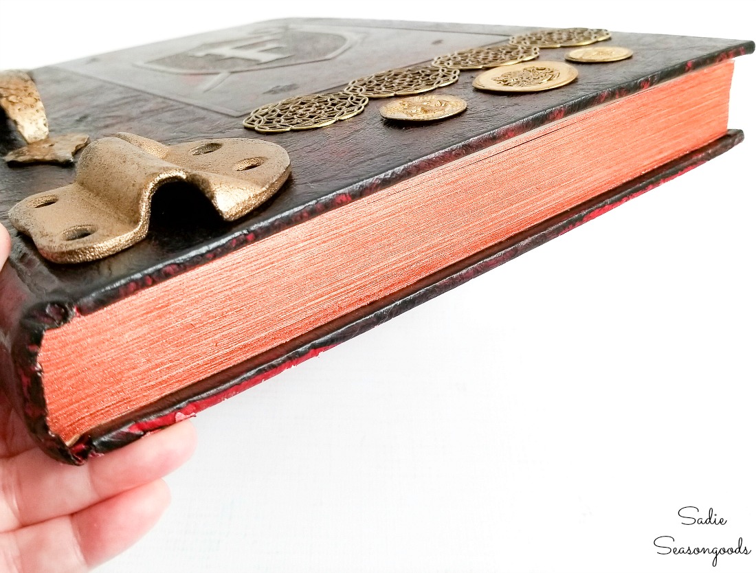 Painting the edges of a Halloween spell book with metallic craft paint