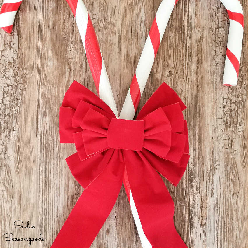 adding a bow to the large candy cane decorations
