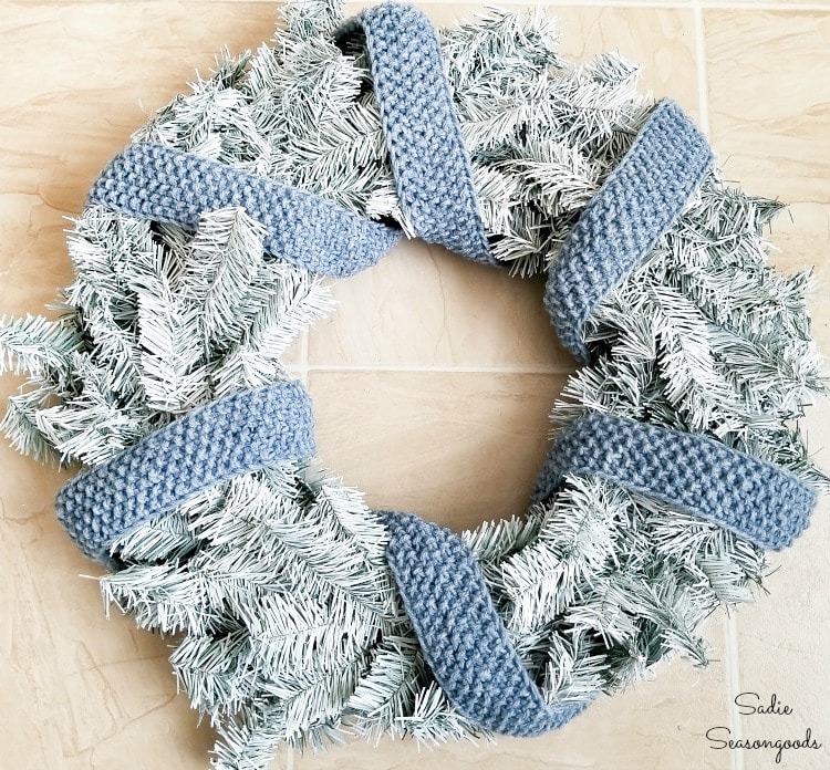 Knitted ribbon as a scarf on a DIY winter wreath