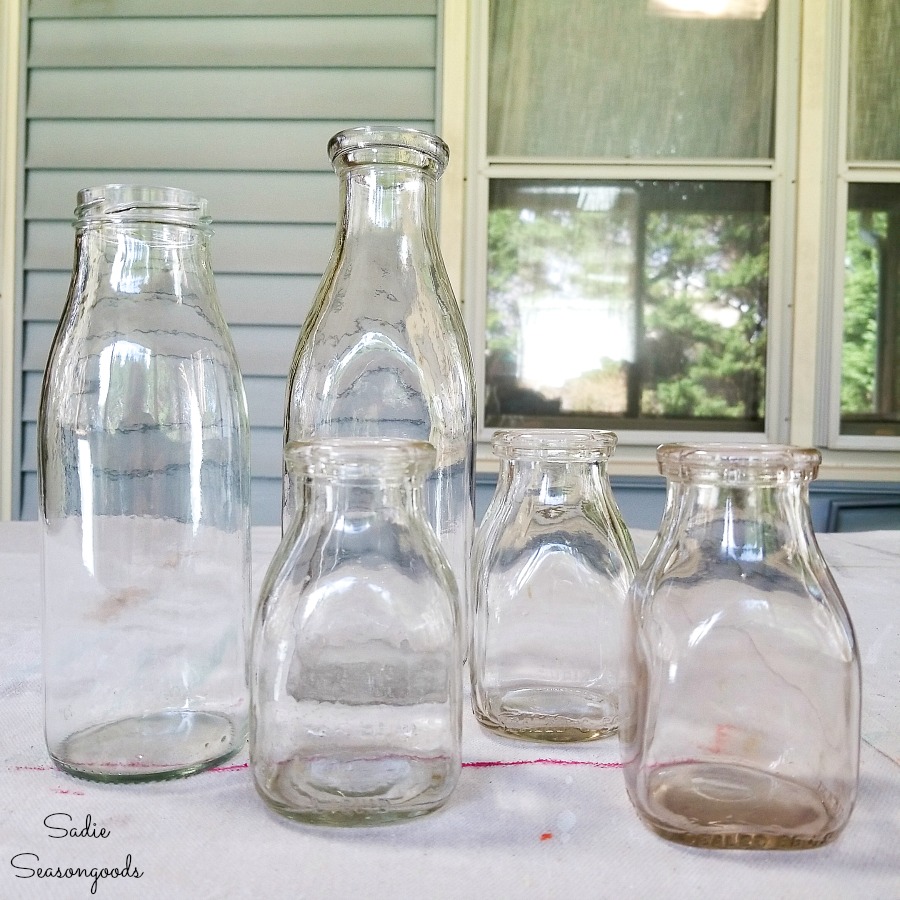 Vintage glass milk bottles to be upcycled into flower vase ideas with milk tops