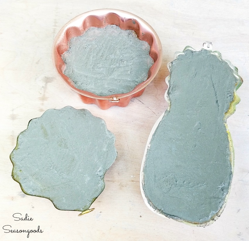 Pouring the cement in the copper jello molds to make the decorative garden stones