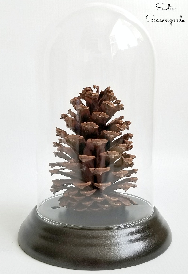 Glass cloche from a dome clock to display the log cabin decor for a winter cabin