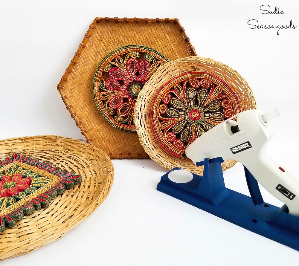 Using hot glue to attach the woven trivets to hanging baskets for a Boho wall hanging or gallery wall
