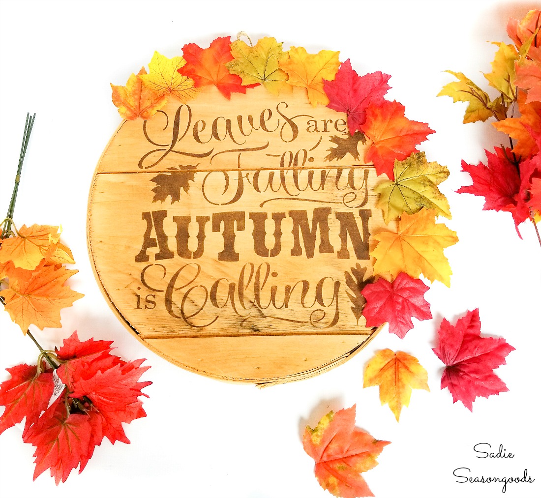 Decorating the lid of a wood cheese box with fall leaves