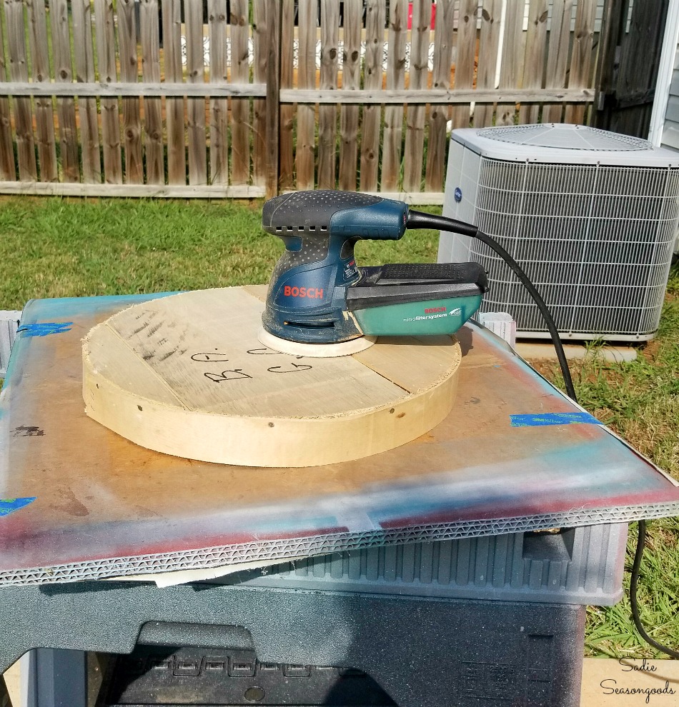 Sanding a wood cheese box to remove writing and marker