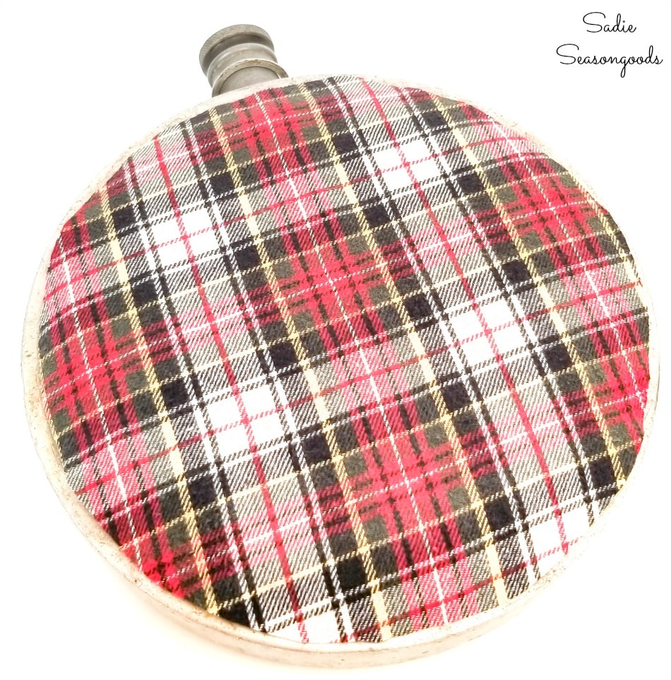 Cutting out the flannel fabric to decoupage on a metal canteen