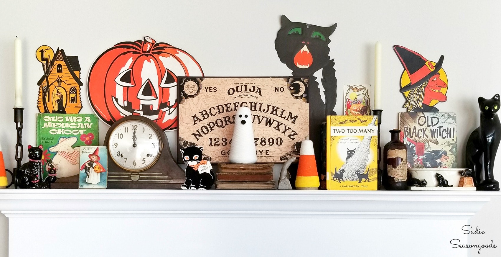 Vintage Halloween cards and door hangers as mantel decor