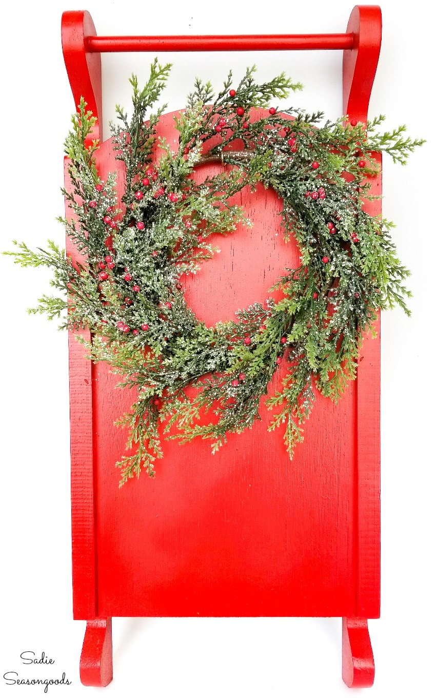 Hanging a wreath on Christmas sled decor