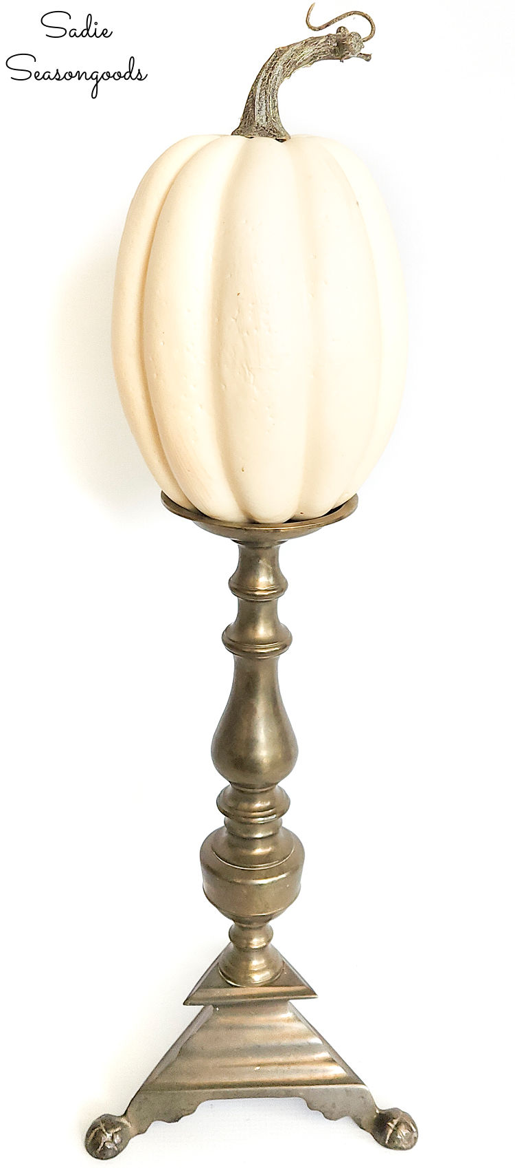 displaying foam pumpkin on a vintage brass candlestick