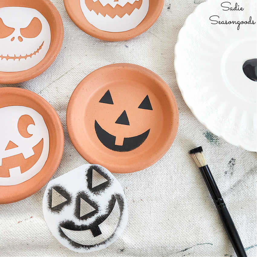 making a pumpkin coaster by stenciling on terracotta