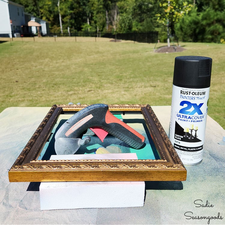 spray painting a picture frame black to use as a halloween tray