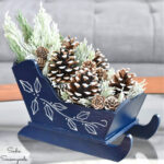 winter centerpiece from a wooden sleigh and snow covered pinecones