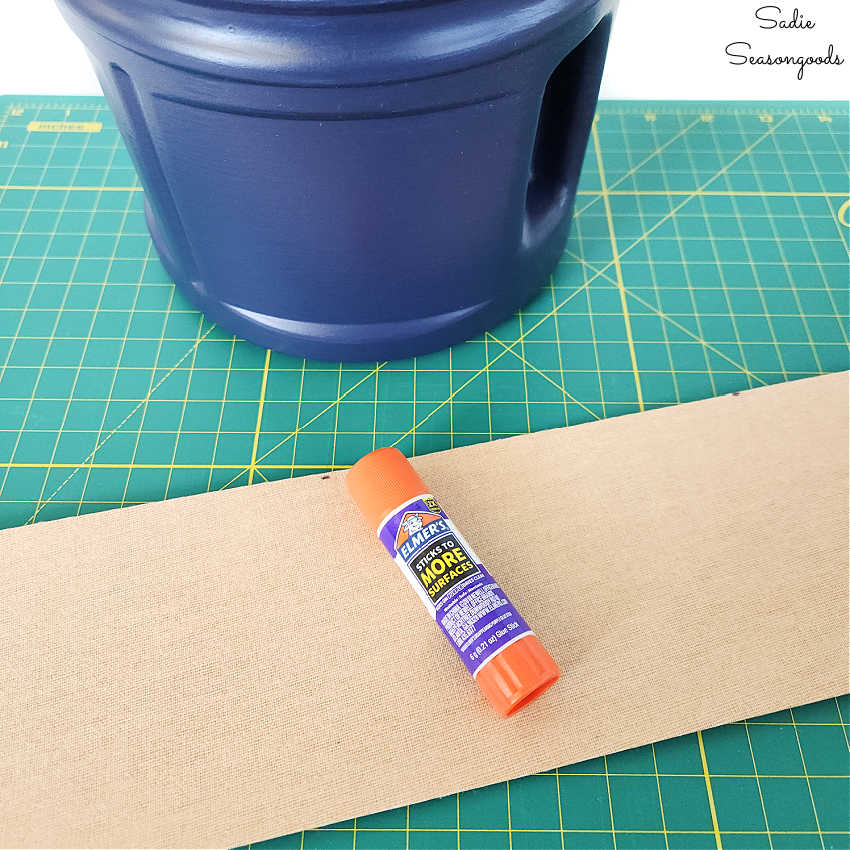 gluing the cork fabric to a coffee canister with a glue stick