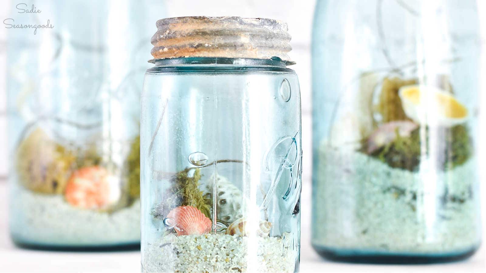 beach sand and shells in a blue mason jar