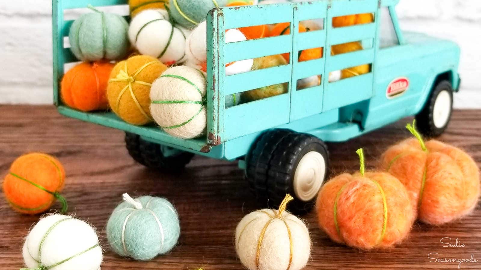 felted wool balls as mini pumpkins in a vintage truck