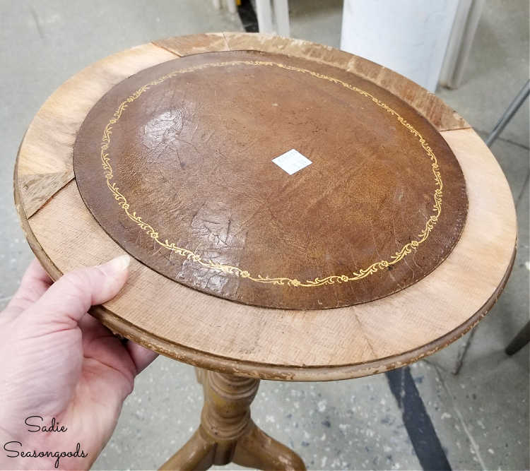 missing veneer on a small round side table