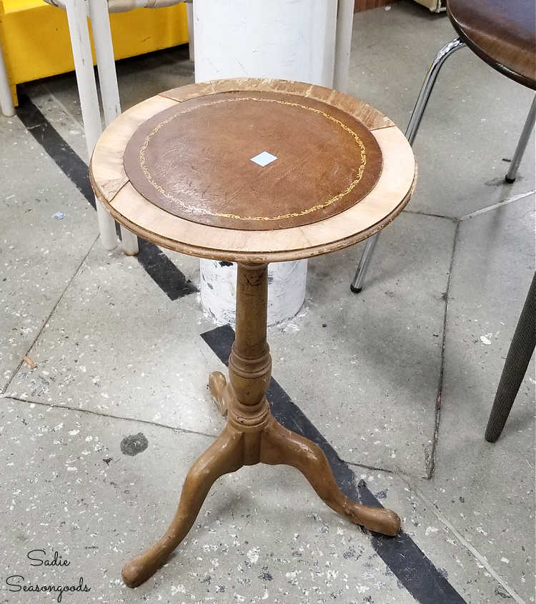small round side table with chipping veneer