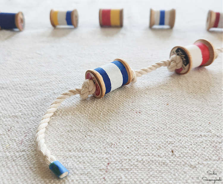 stringing painted spools to look like a buoy garland