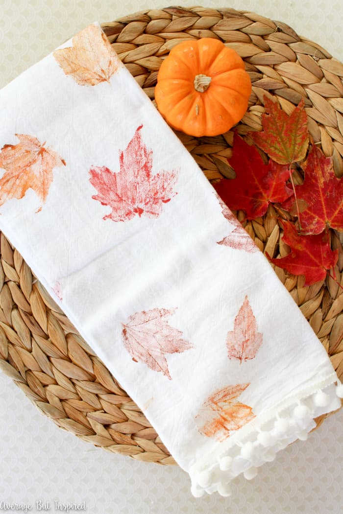 stamping a tea towel with fall leaves